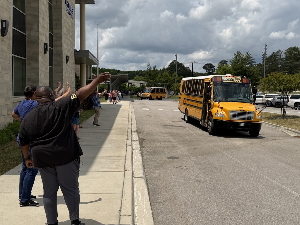 Faculty and staff wave goodbye to students on the school buses leaving Fulmer for summer break.