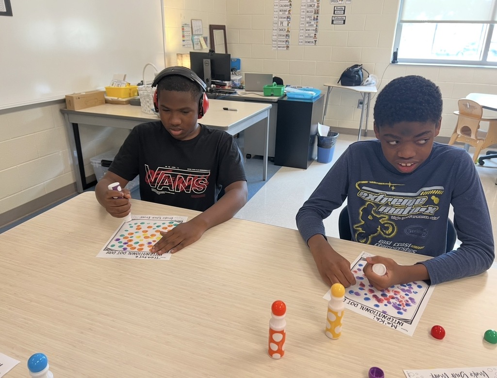 Two students are creating dot art with dot stampers.