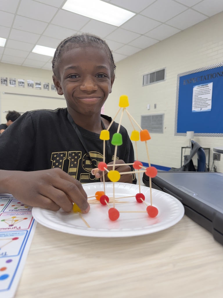 A student is shown with the DOT candy structure he built using toothpicks and DOT gummy candy.