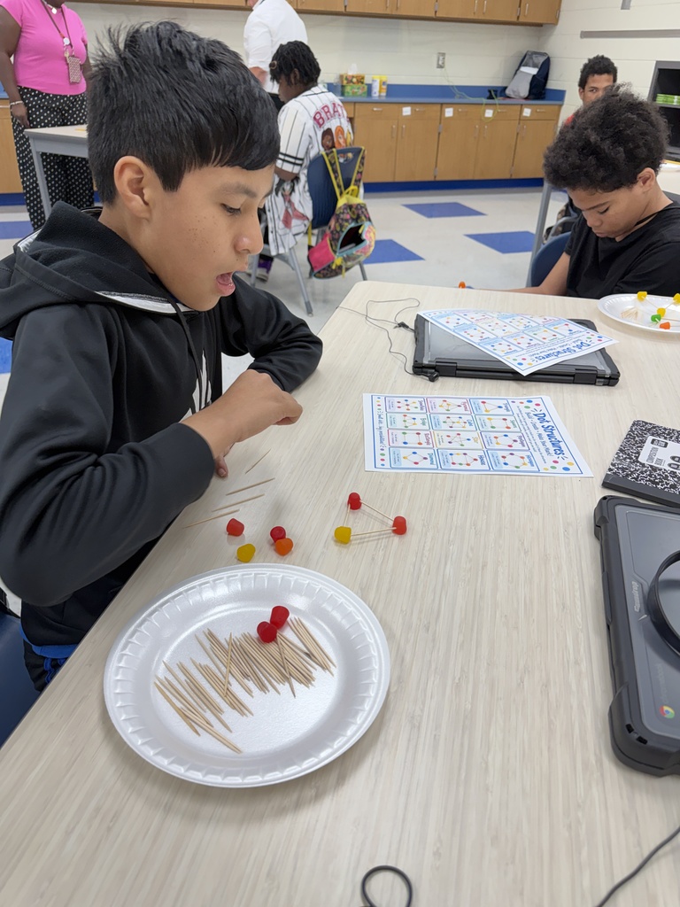 A student is shown building his dot structure with toothpicks and DOT gummy candy.