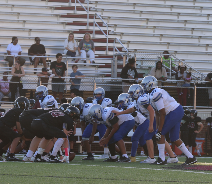 The Airport C-Team football players are shown at ready formation before the ball is snapped by the center.