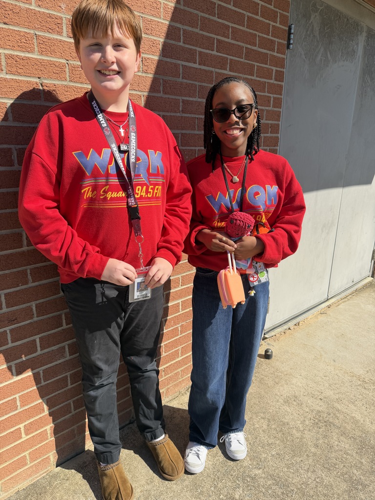Two students stand side by side smiling at the camera wearing the exact clothing attire for Twin Day at school. 