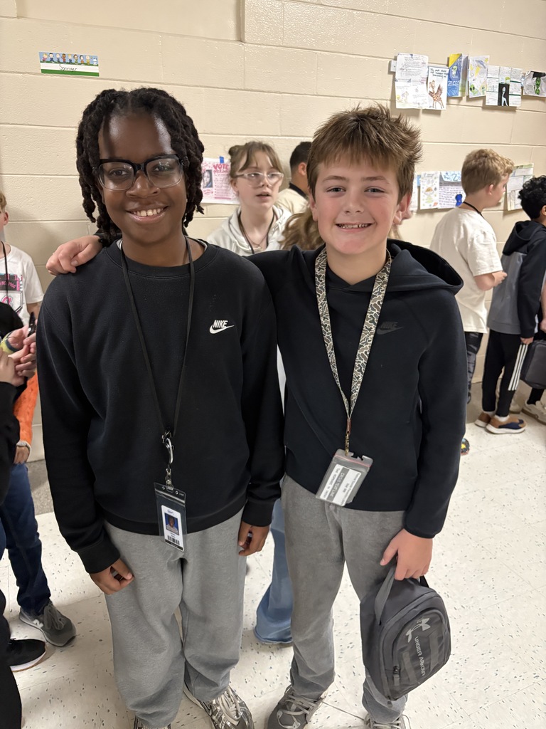 Two students stand side by side smiling at the camera wearing the exact clothing attire for Twin Day at school. 