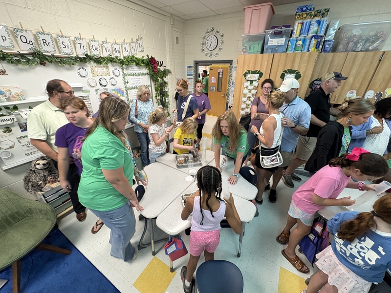 Parents look at some students projects in a classroom