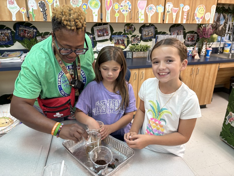 Students and a teacher perform soil experiments