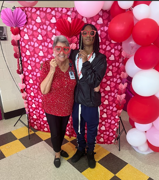 Mrs. Brown and Malachi pose at the photobooth at the 8th grade dance on Thursday
