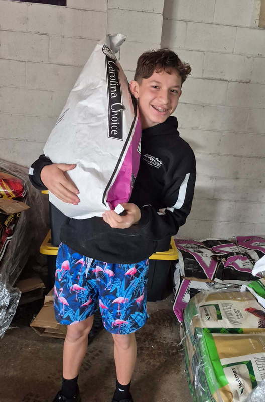 Alex Shull lifing feed at Locklair Feed & Seed