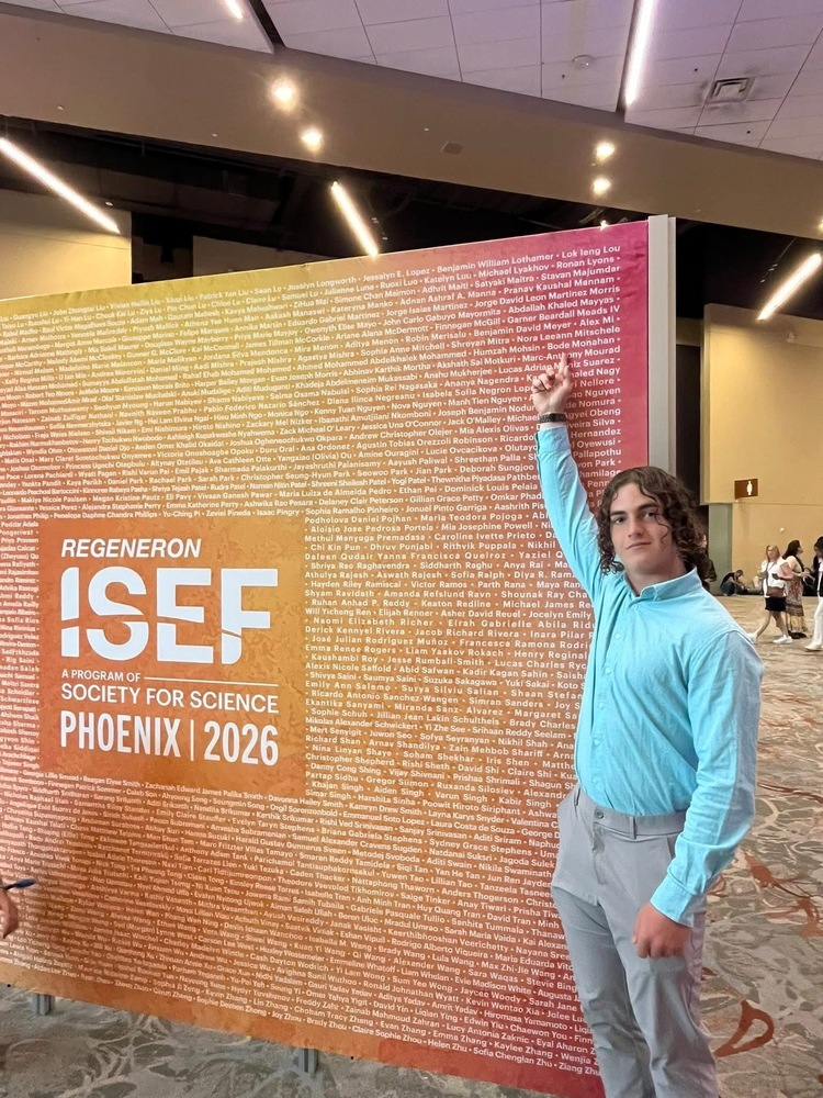 Sophomore Bode Monahan poses in front of the ISEF List of Qualifiers backdrop in Phoenix.