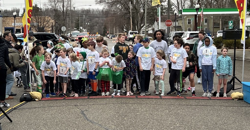 group of kids standing at the finish line for a group photo