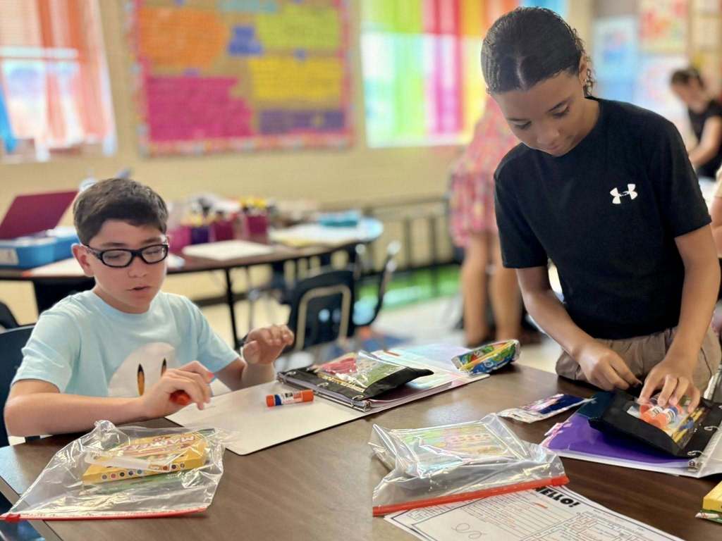 Fifth grade students put away school supplies