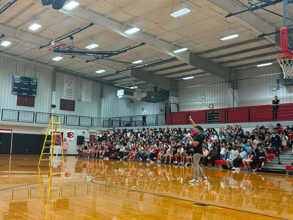 Nathan Harmon speaks to a gym full of Elkmont High School students.