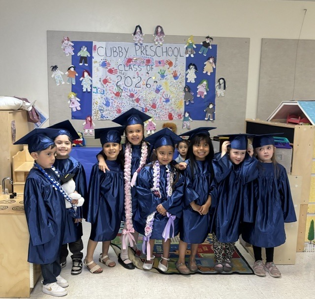Image of preschoolers in graduation gowns