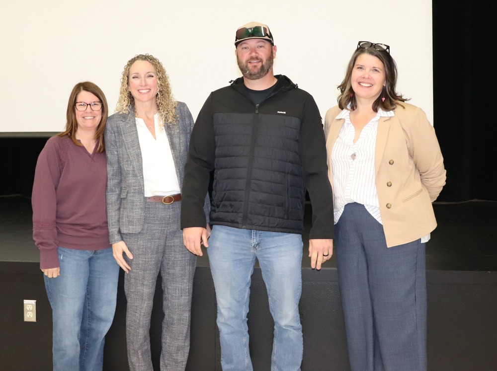 4 people standing in front of a stage