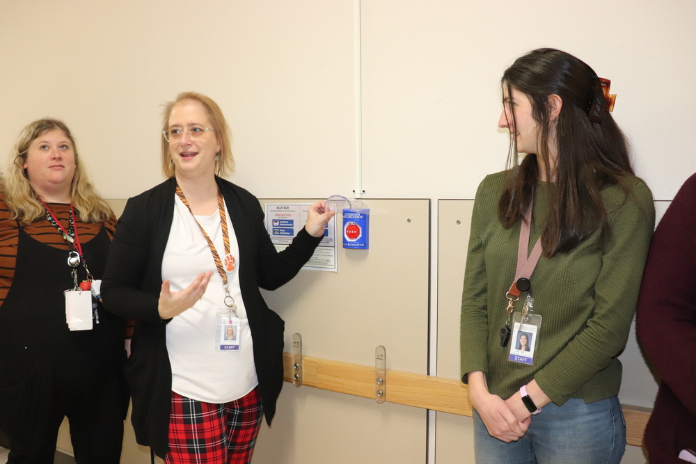 Three women standing in school hallway