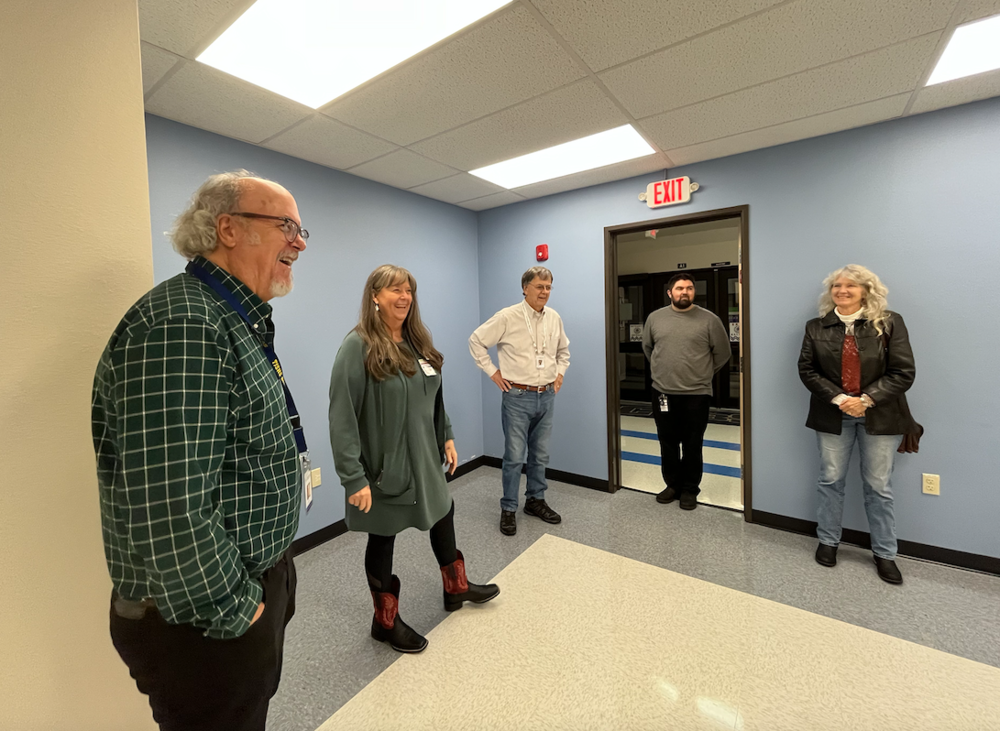 Board members standing in new office space