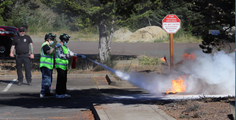 Teen CERT students extinguish a fire in training