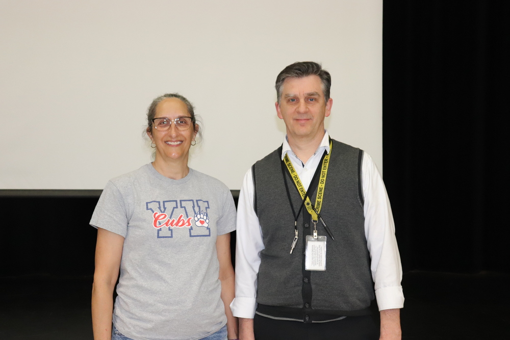 A middle aged woman standing next to a middle aged man