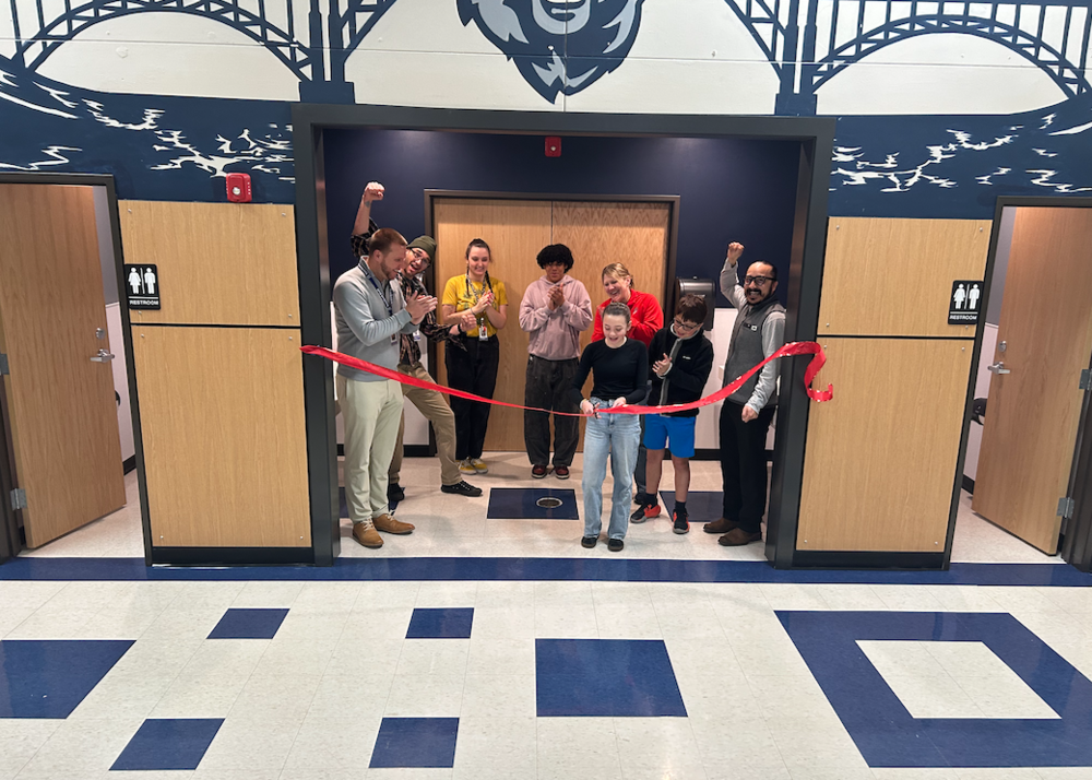 Young girl cutting a red ribbon