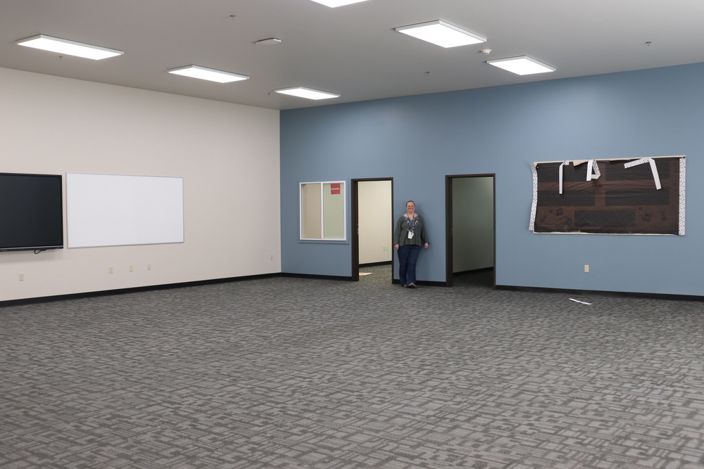Woman standing against a blue wall in a large empty room