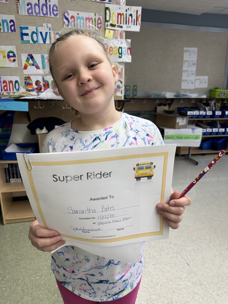 Smiling student holding certificate that says 'Super Rider'.