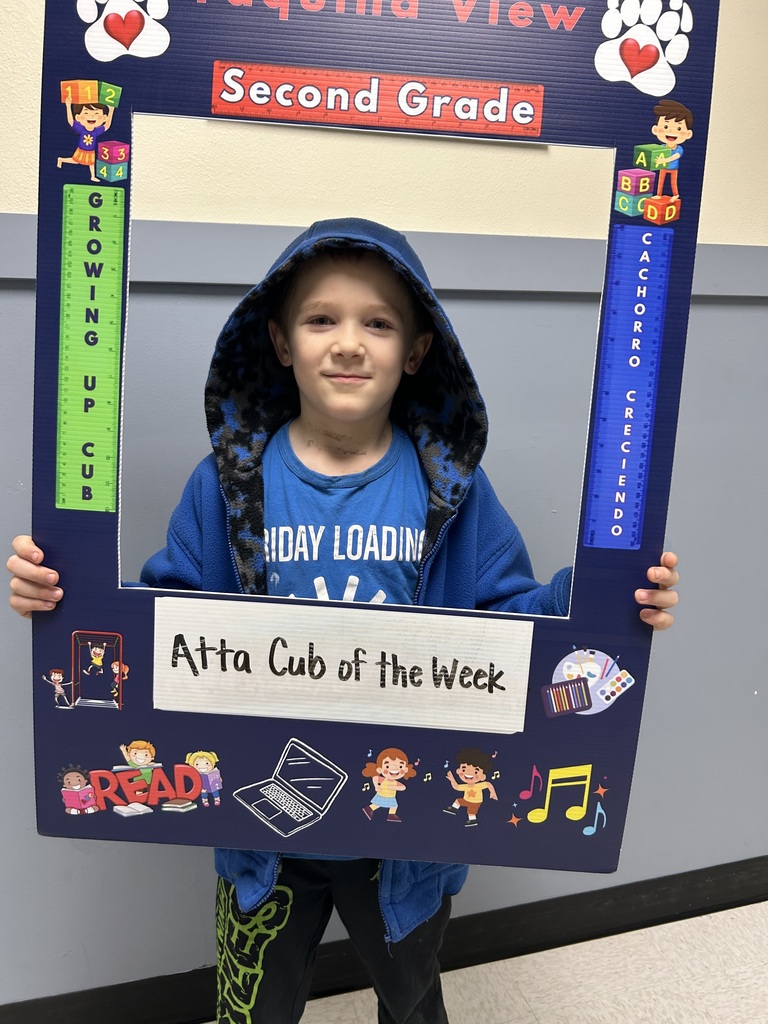 Smiling male student holding up Atta Cub Kid of the Week picture frame.
