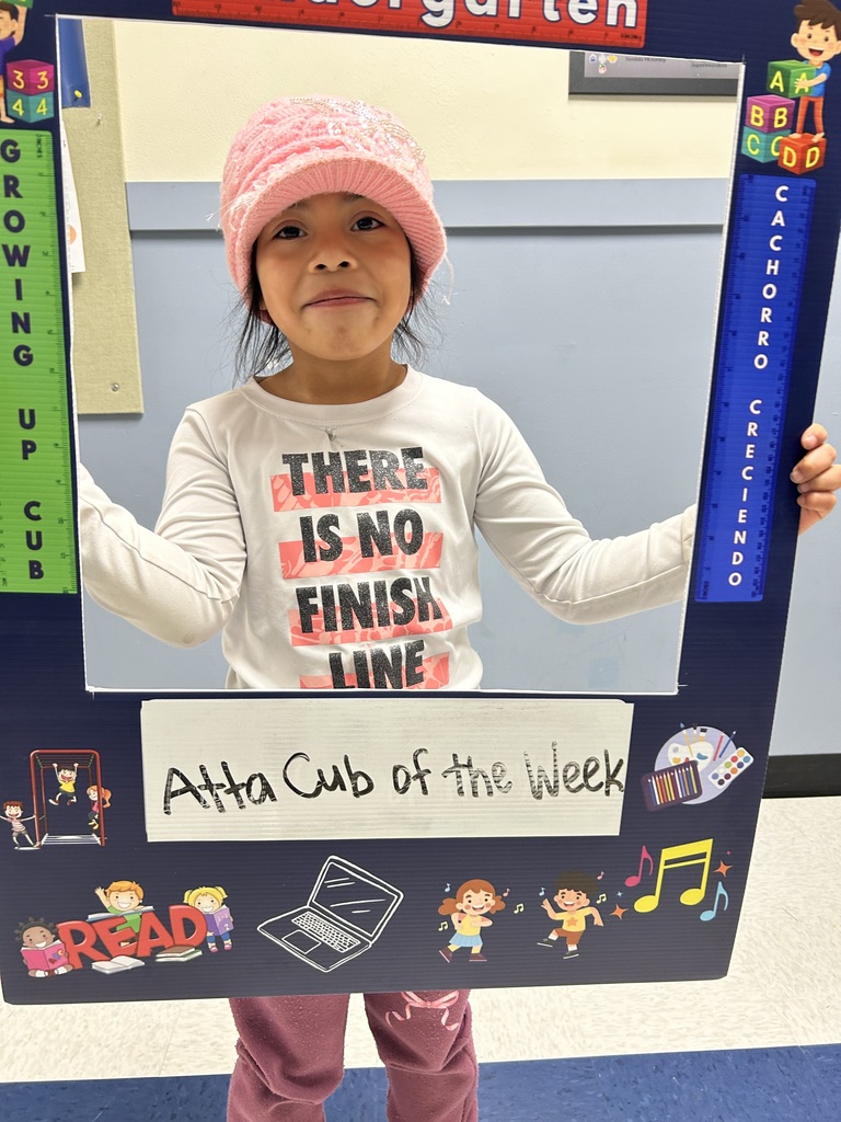 Smiling girl student holding up Atta Cub Kid of the Week picture frame.