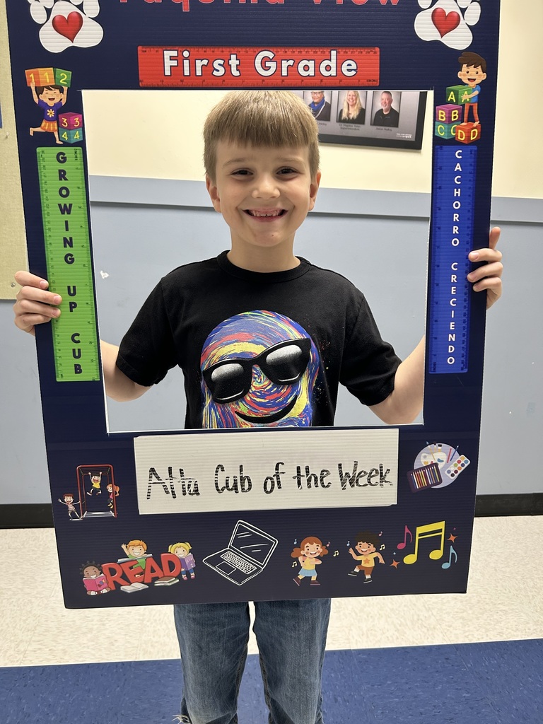 Smiling male student holding up Atta Cub Kid of the Week picture frame.