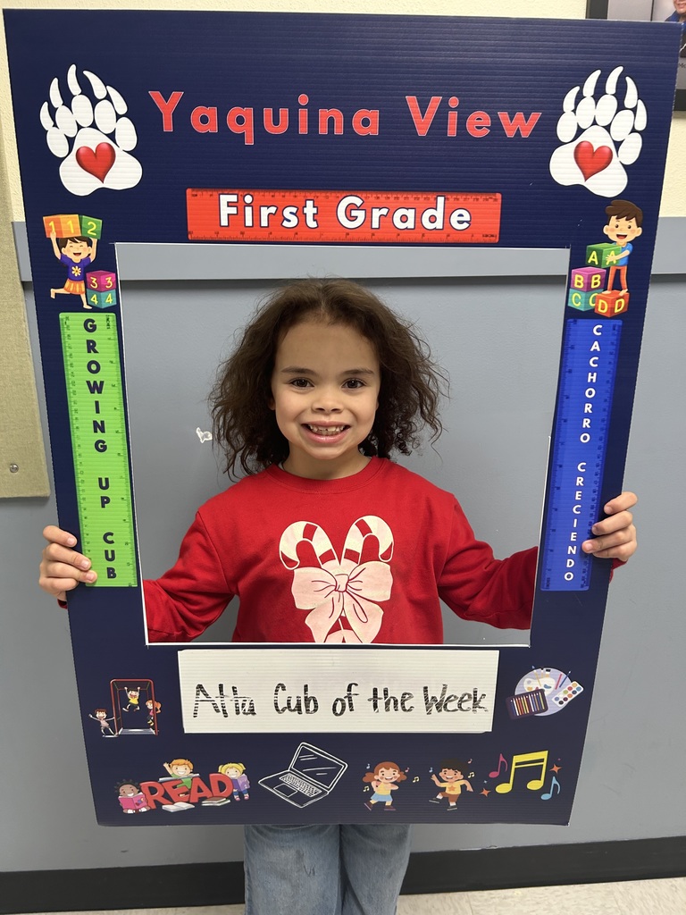 Smiling girl child holding a picture frame saying Atta Cub Kid of the Week