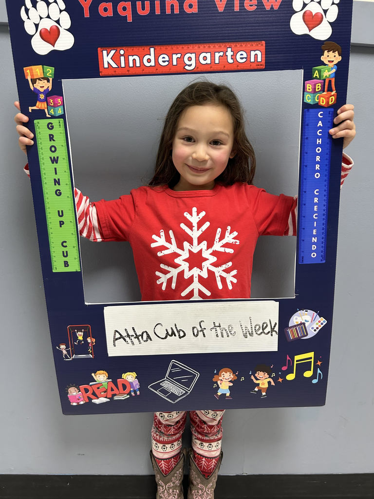Smiling girl holding up Atta Cub kid of the week picture frame. 