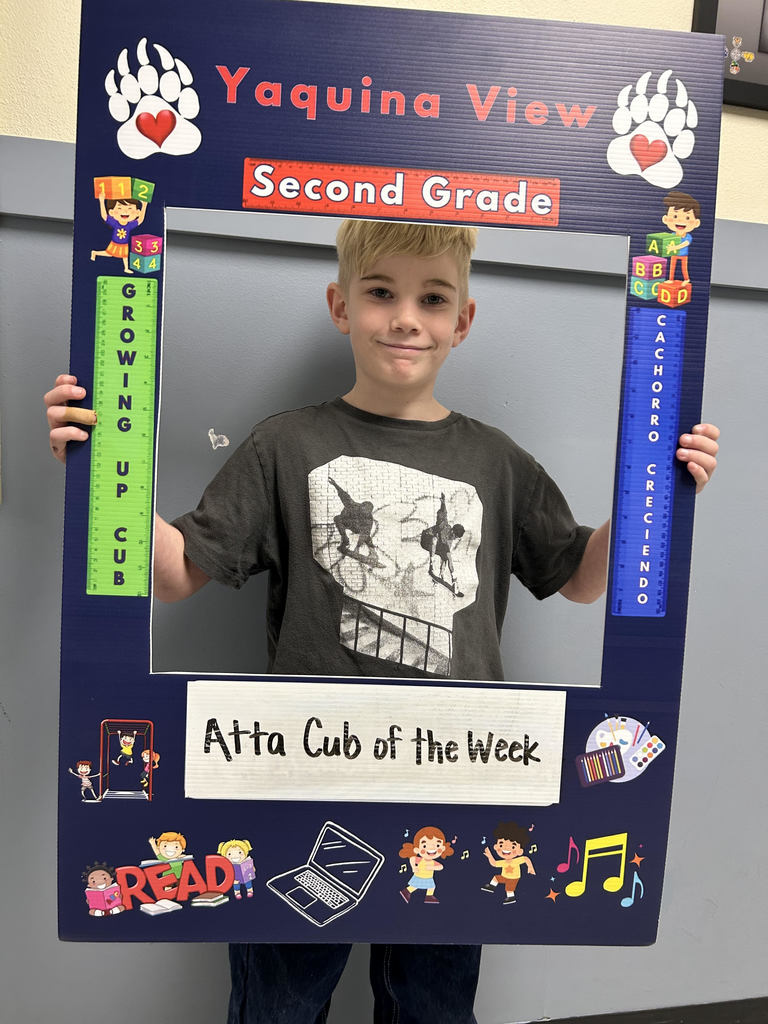 Smiling boy holding up Atta Cub kid of the week picture frame. 