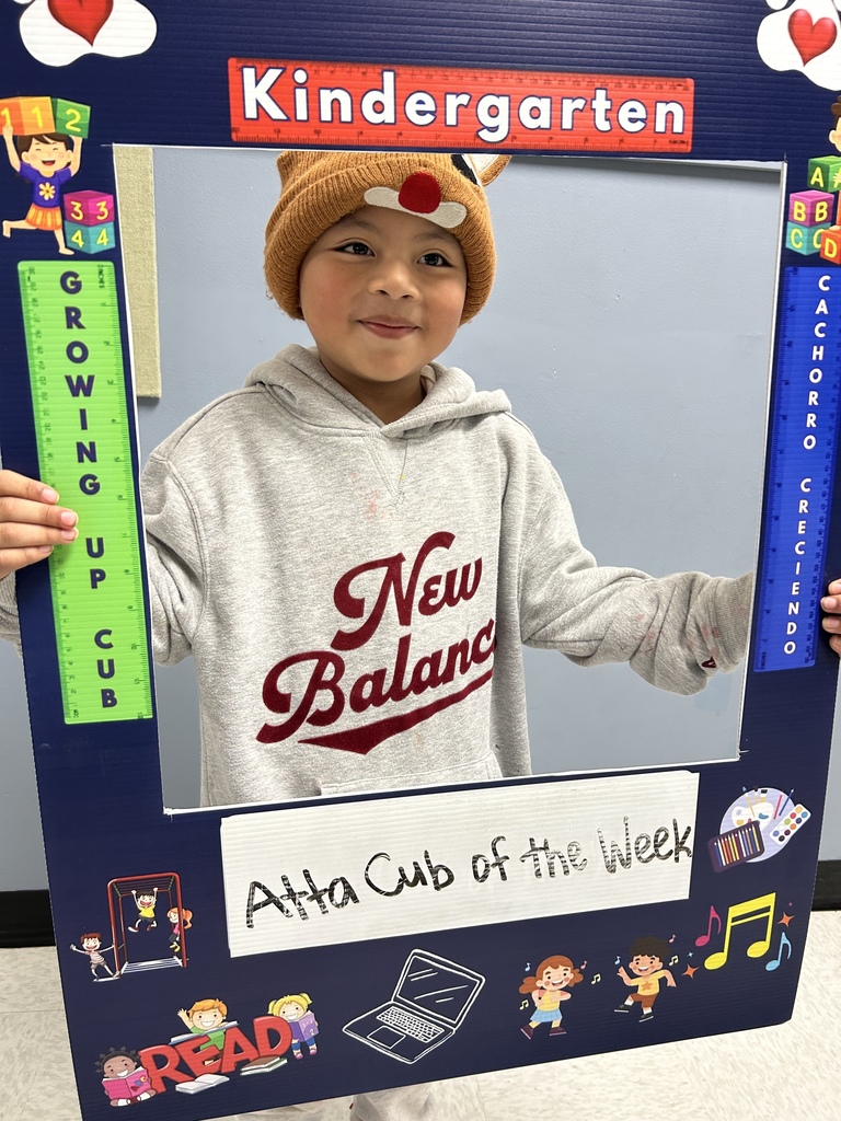 Smiling boy holding up Atta Cub kid of the week picture frame. 