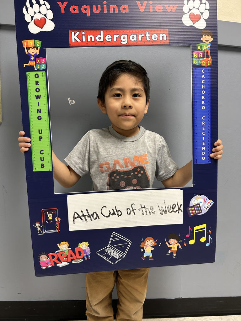 Smiling boy holding up Atta Cub kid of the week picture frame. 