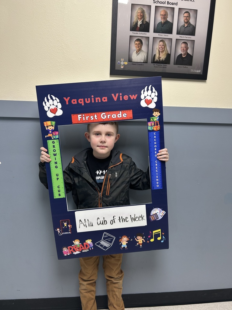 Smiling boy holding Atta Cub Kid of the week frame. 