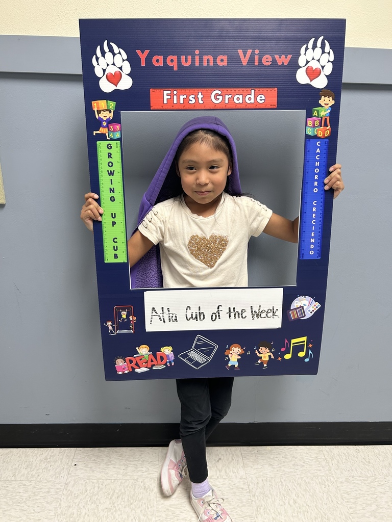 Smiling girl holding Atta Cub Kid of the Week picture frame. 