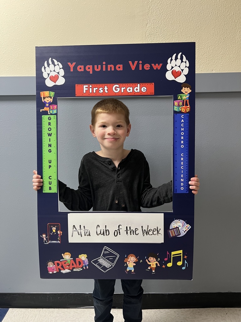 Smiling boy holding Atta Cub Kid of the week picture frame