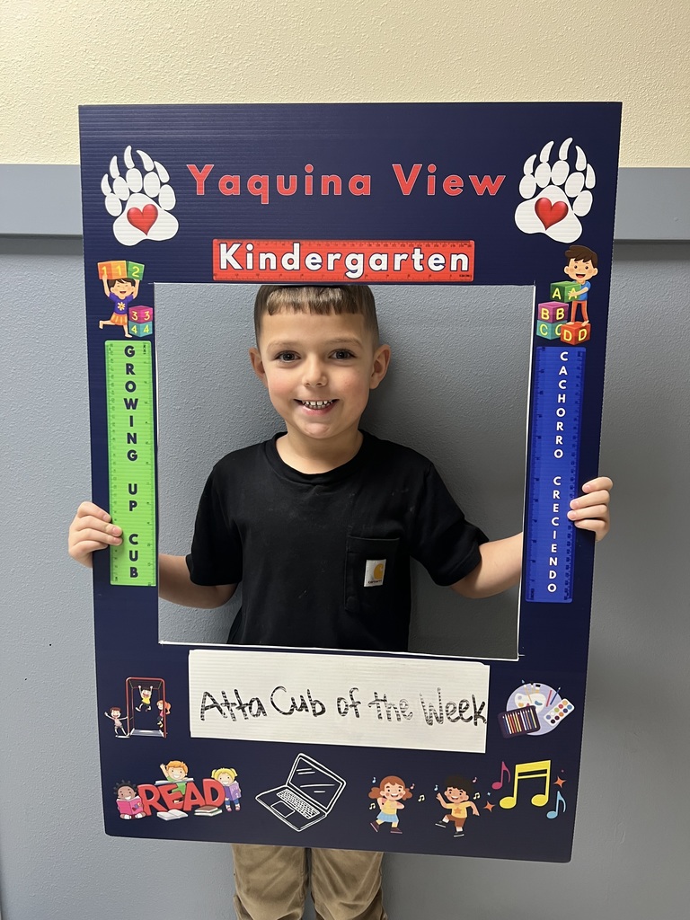 Smiling boy holding Atta Cub Kid of the week picture frame