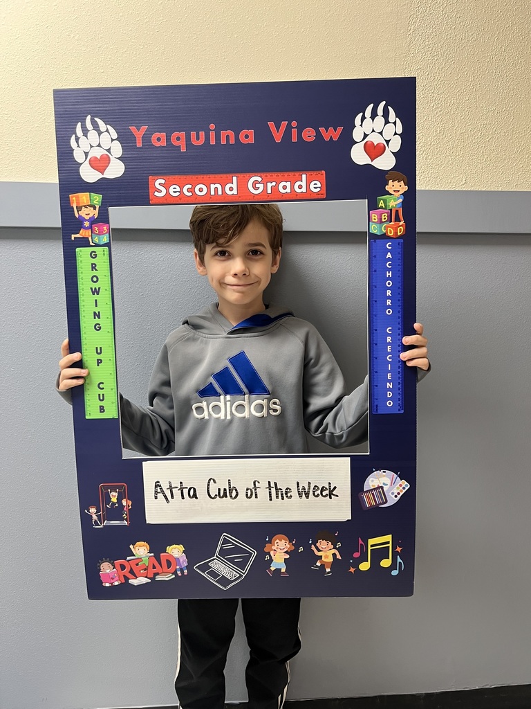 Smiling boy holding Atta Cub Kid of the week picture frame