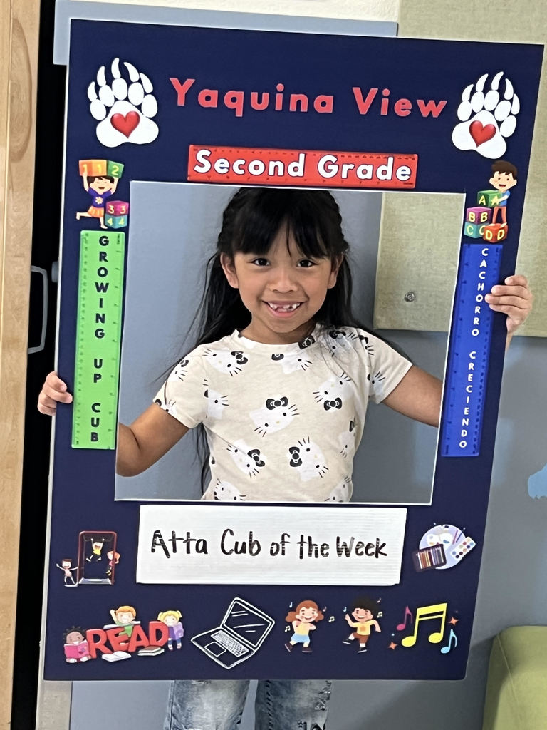 Smiling girl holding Atta Cub Kid of the Week frame.