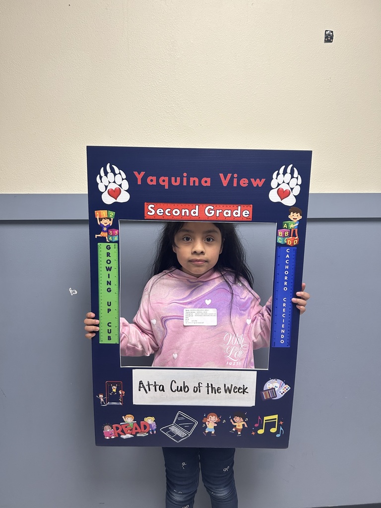 Smiling girl holding Atta Cub Kid of the Week frame.