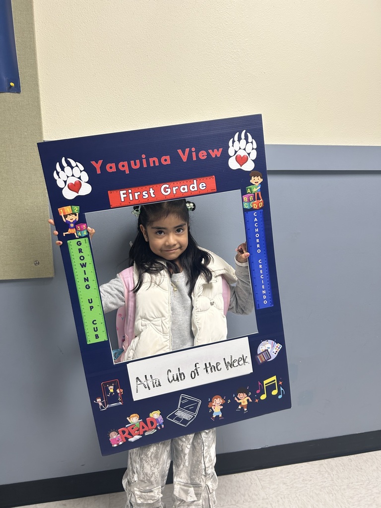 Smiling girl holding Atta Cub Kid of the Week frame.