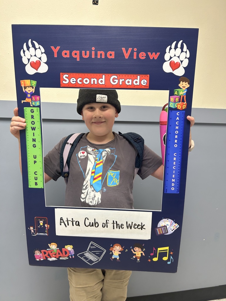 Smiling boy holding Atta Cub Kid of the Week frame.