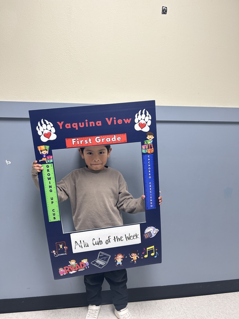 Smiling boy holding Atta Cub Kid of the Week frame.