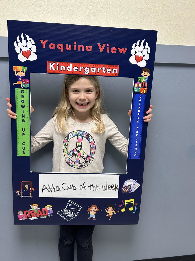 Smiling girl holding Atta Cub kid of the week frame