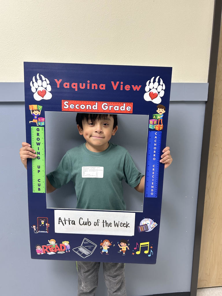 Smiling boy holding Atta Cub kid of the week frame