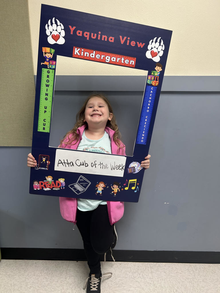 Smiling girl holding Atta Cub Kid of the week frame.