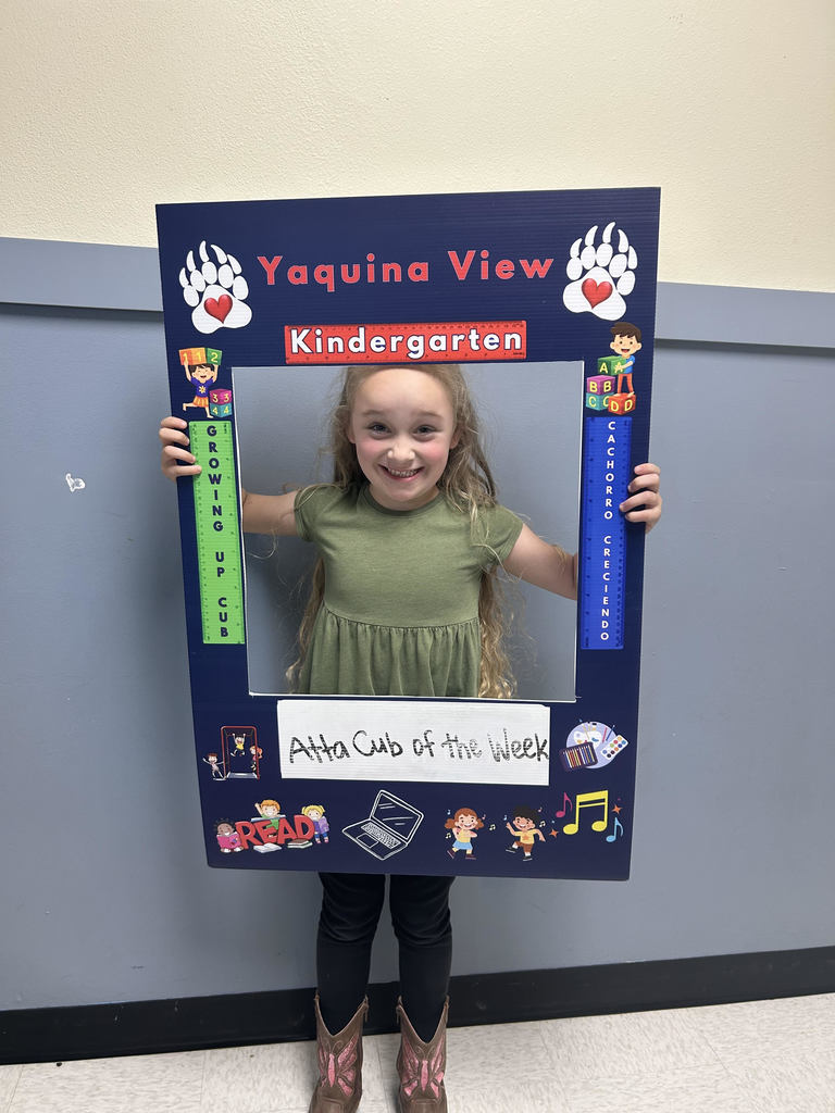 Smiling girl holding Atta Cub Kid of the week frame.
