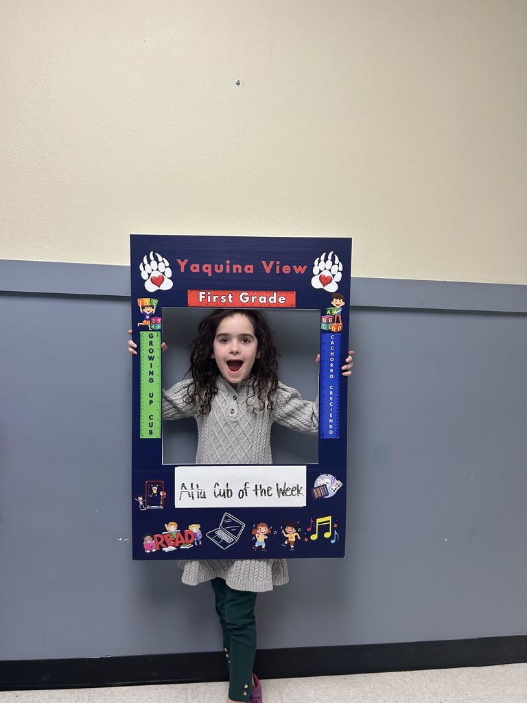 Smiling girl holding Atta Cub Kid of the week frame.
