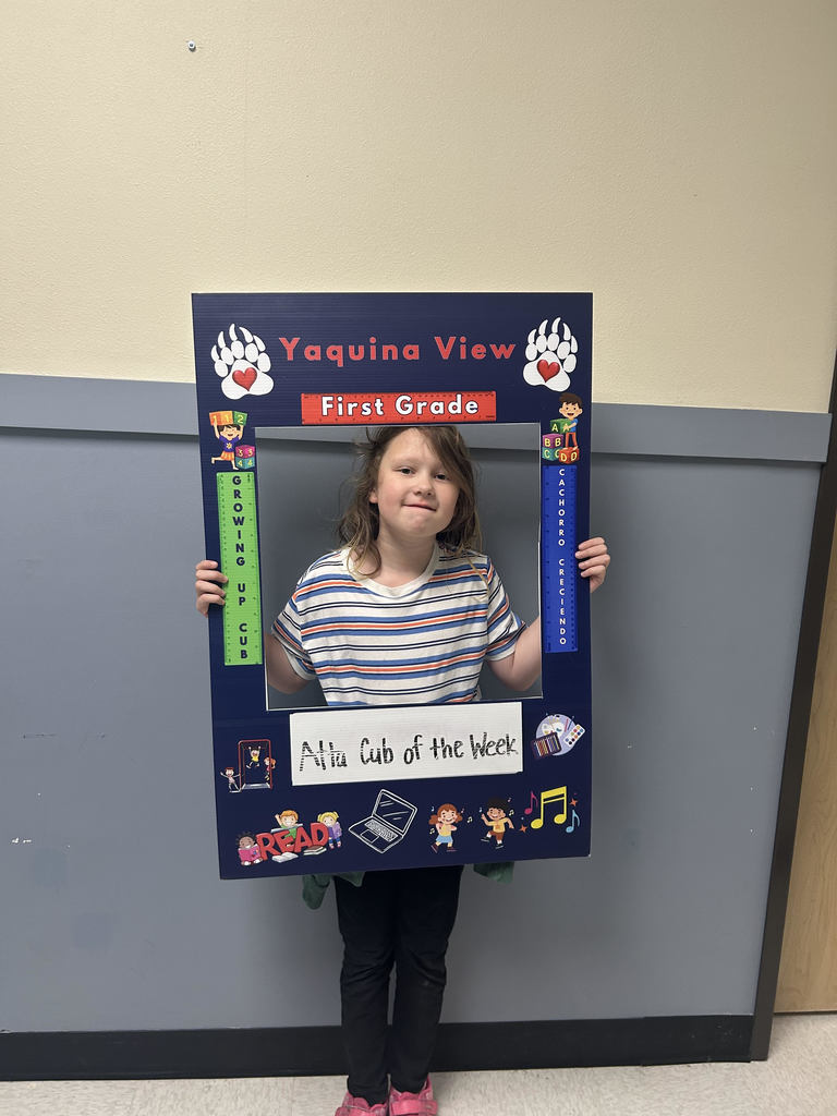 Smiling girl holding Atta Cub Kid of the Week picture frame