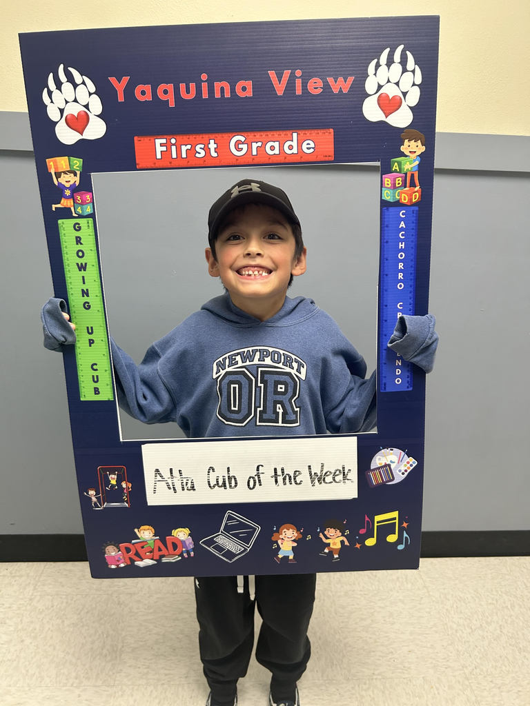 Smiling boy holding Atta Cub Kid of the Week picture frame
