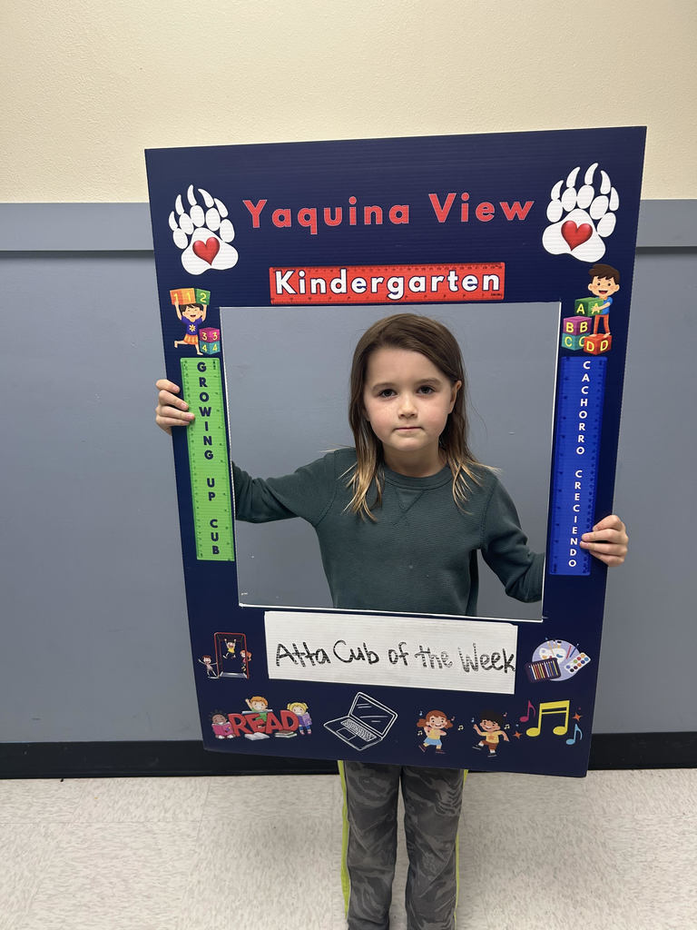 Smiling girl holding Atta Cub Kid of the Week picture frame